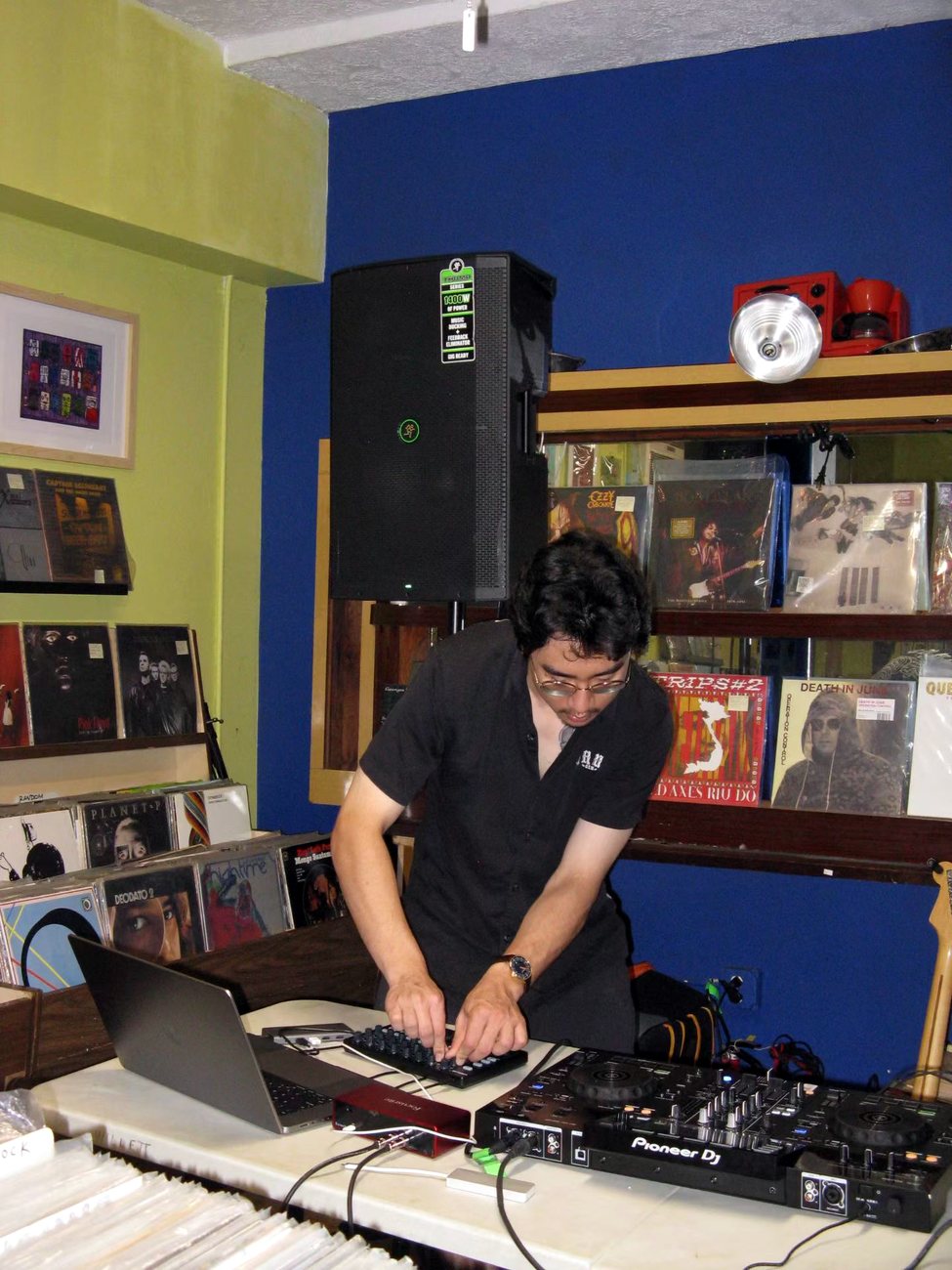 Warren performing electronic music surrounded by records